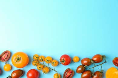 Flat lay composition with fresh ripe tomatoes on light blue background. Space for text