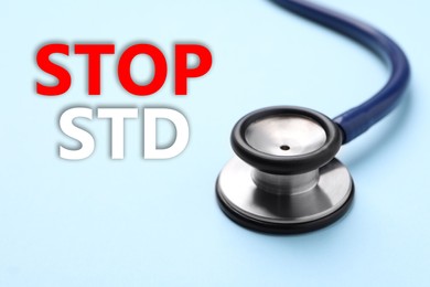 Text STOP STD and stethoscope on light blue background, closeup