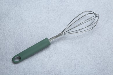 Photo of Metal whisk on gray table, top view