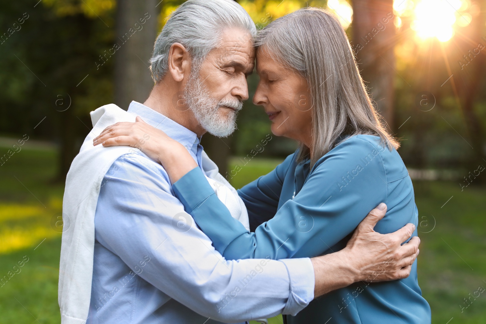 Photo of Affectionate senior couple spending time together in park. Romantic date