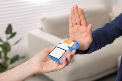 Photo of Woman refusing cigarettes at home, closeup. Quitting smoking concept