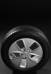 Photo of Car tire with rim on dark background