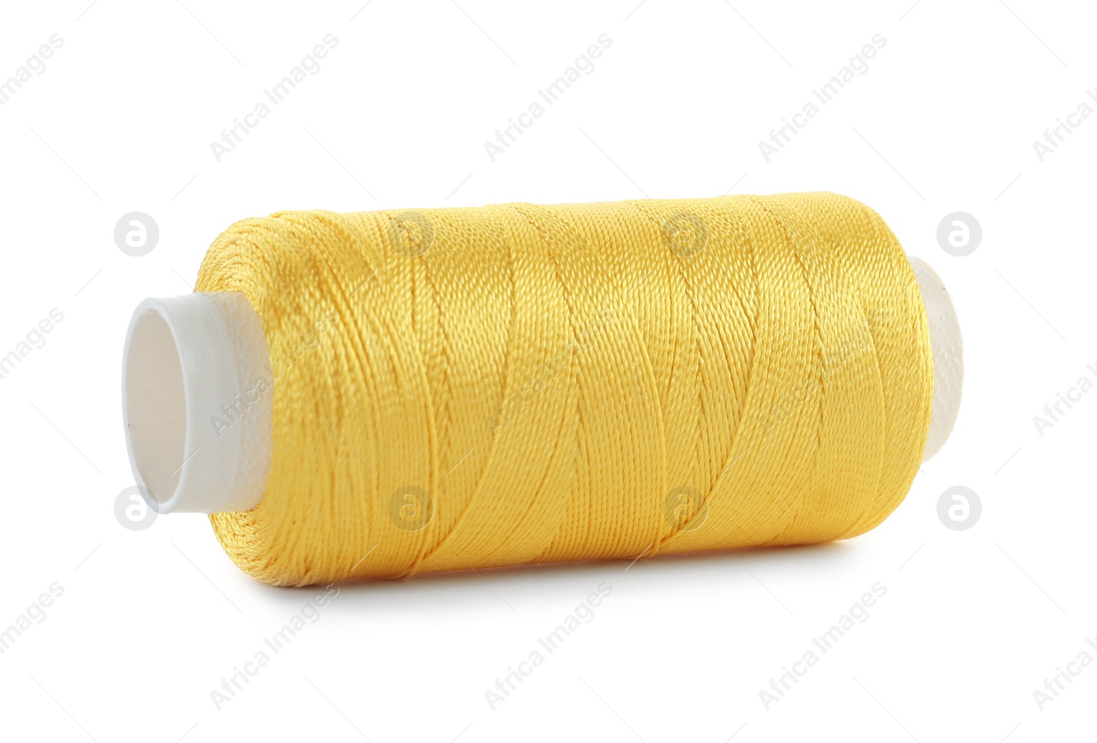 Photo of Spool of yellow sewing thread isolated on white