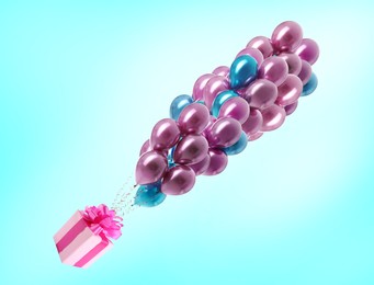 Many balloons tied to pink gift box on light blue background