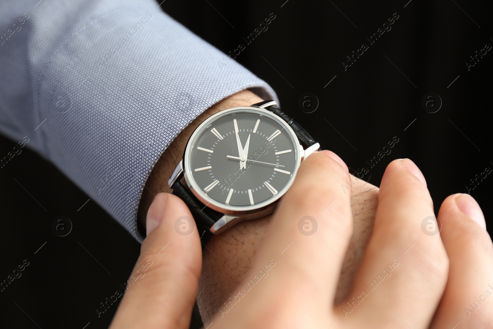 Photo of Man with luxury wrist watch on black background, closeup