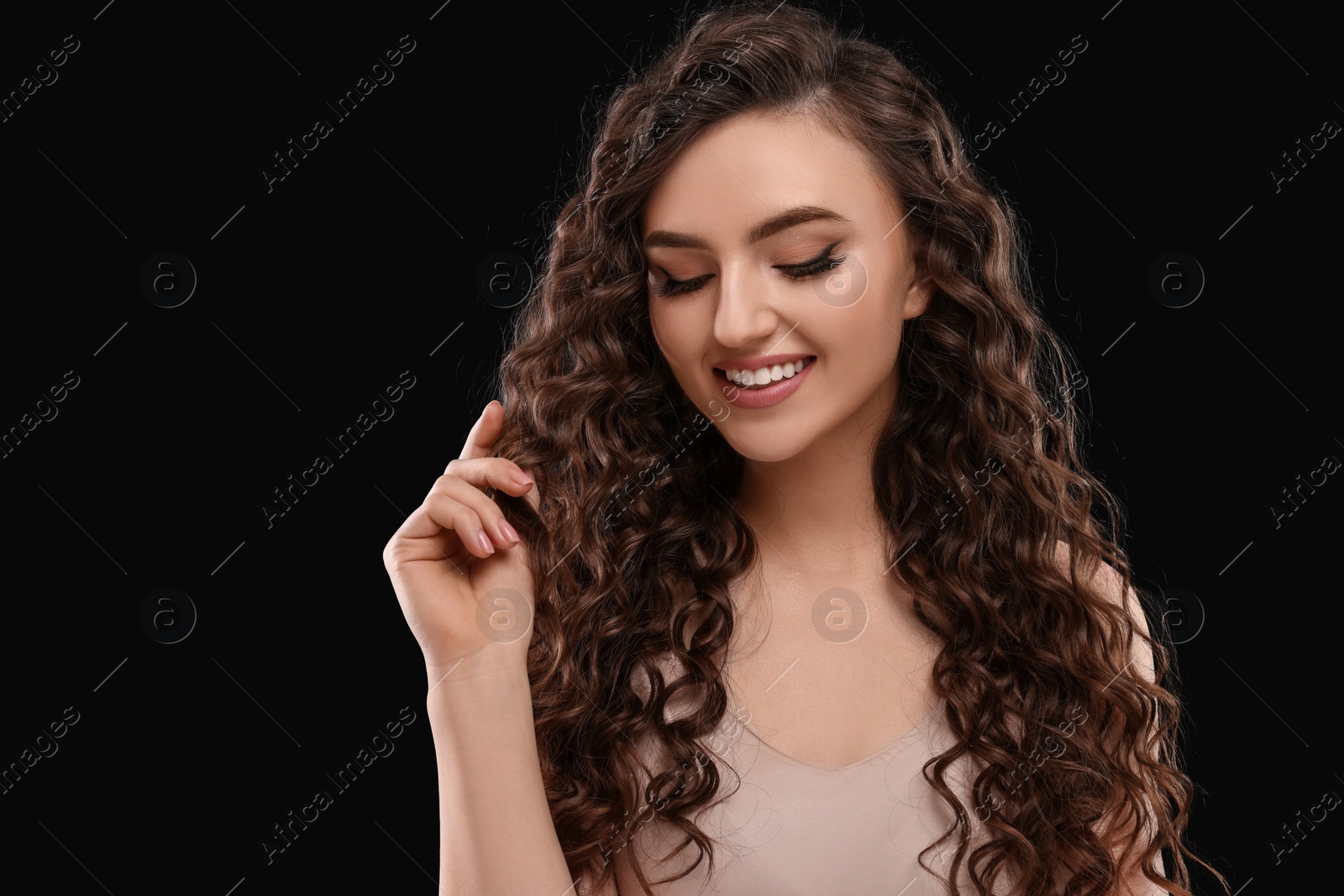 Photo of Beautiful young woman with long curly hair on brown background, space for text