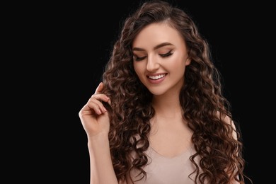 Photo of Beautiful young woman with long curly hair on brown background, space for text
