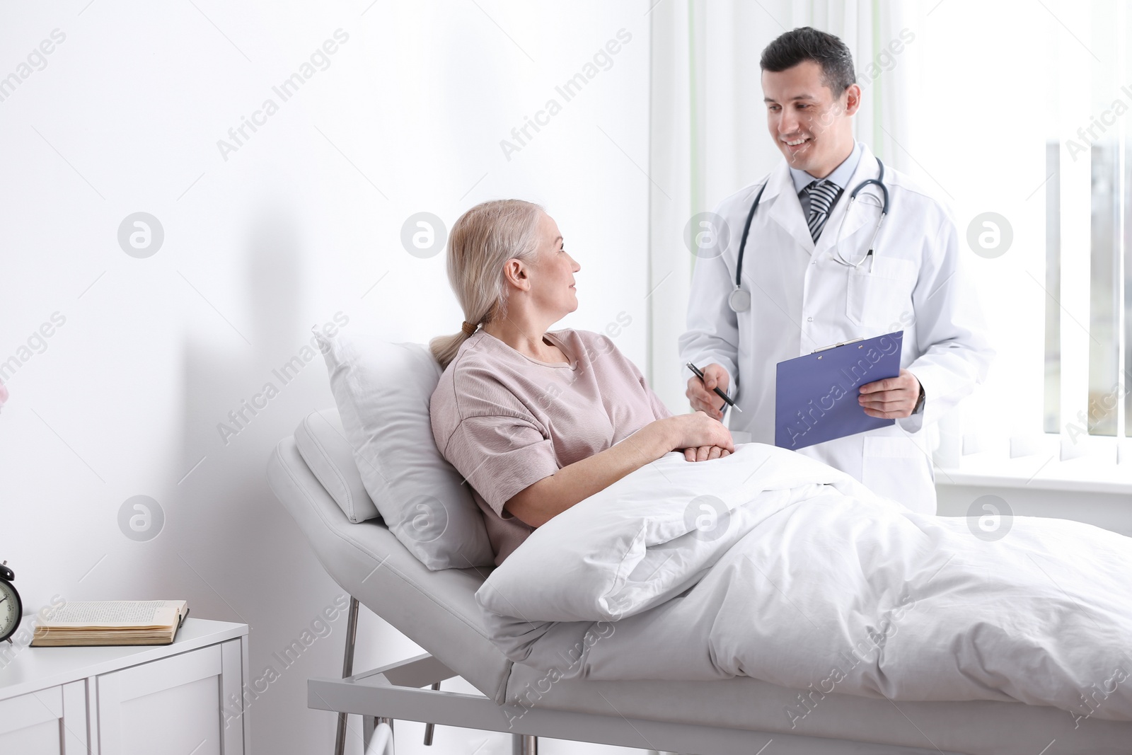 Photo of Doctor visiting his patient in hospital ward