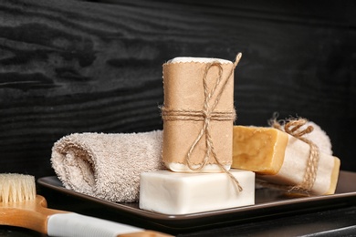 Photo of Plate with soap bars and towel on table