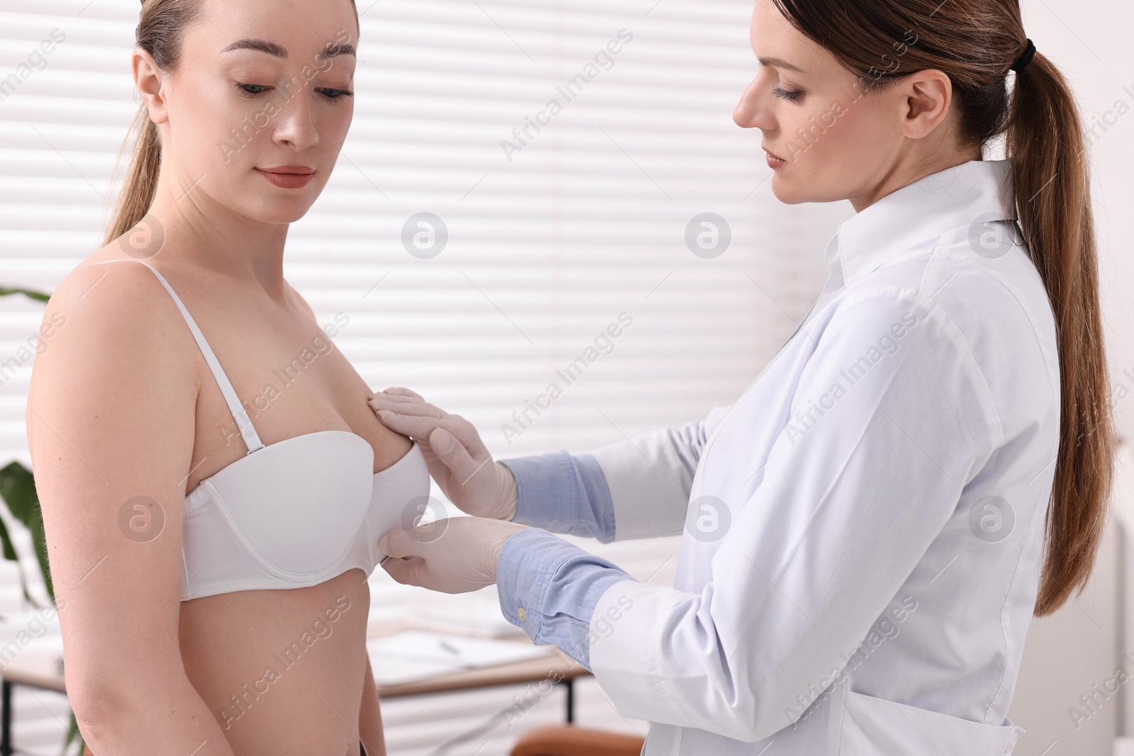 Photo of Mammologist checking young woman's breast in hospital