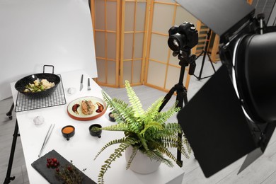 Photo of Professional equipment and composition with delicious meat medallion on white table in studio. Food photography