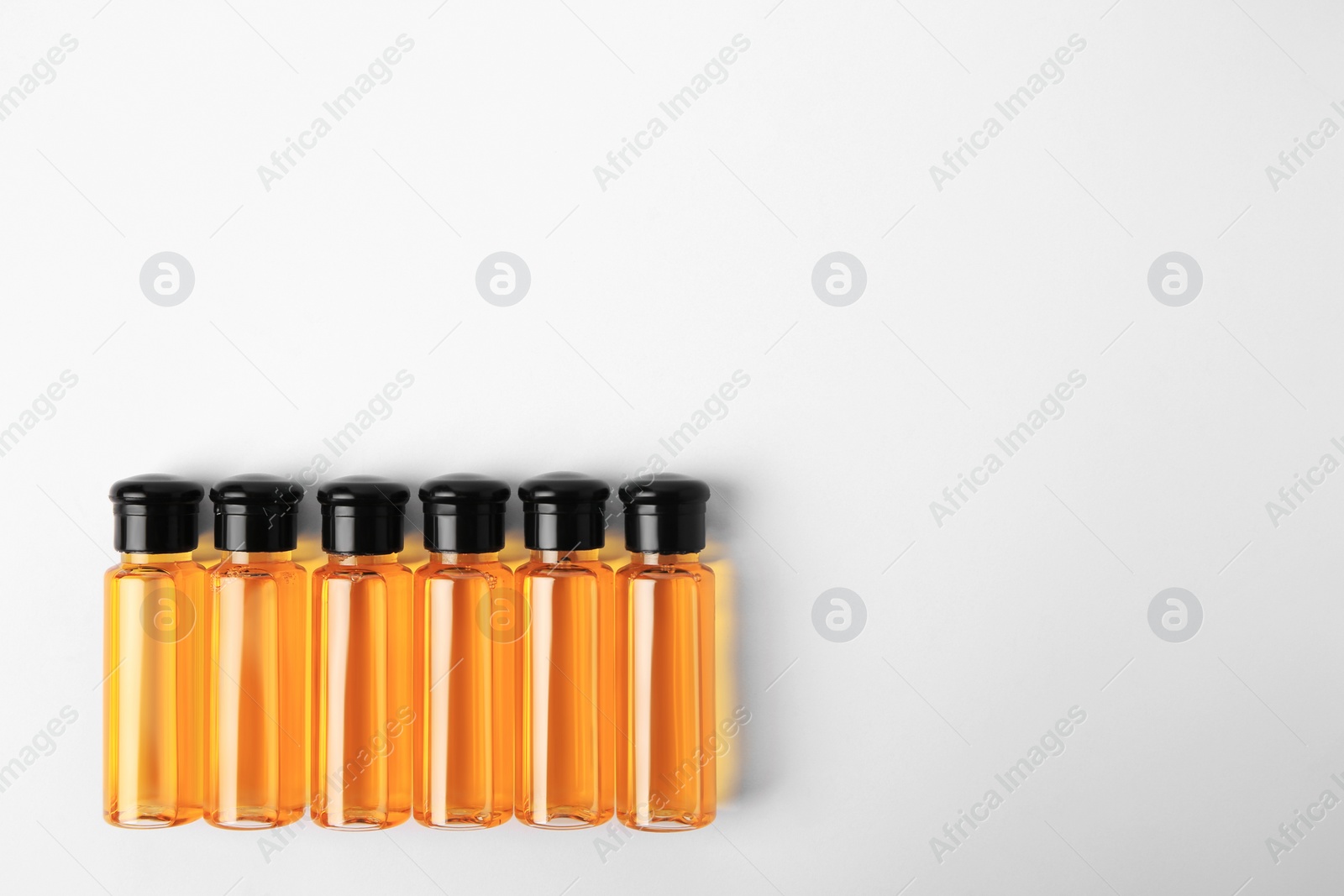 Photo of Bottles of cosmetic products on white background, flat lay. Space for text