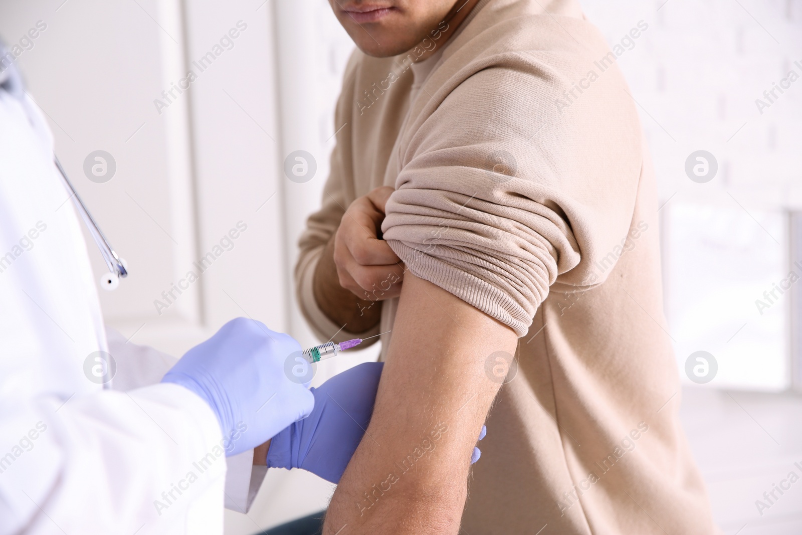 Photo of Doctor giving injection to patient in hospital, closeup. Vaccination concept