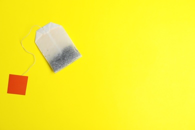 Photo of Tea bag on color background, top view with space for text