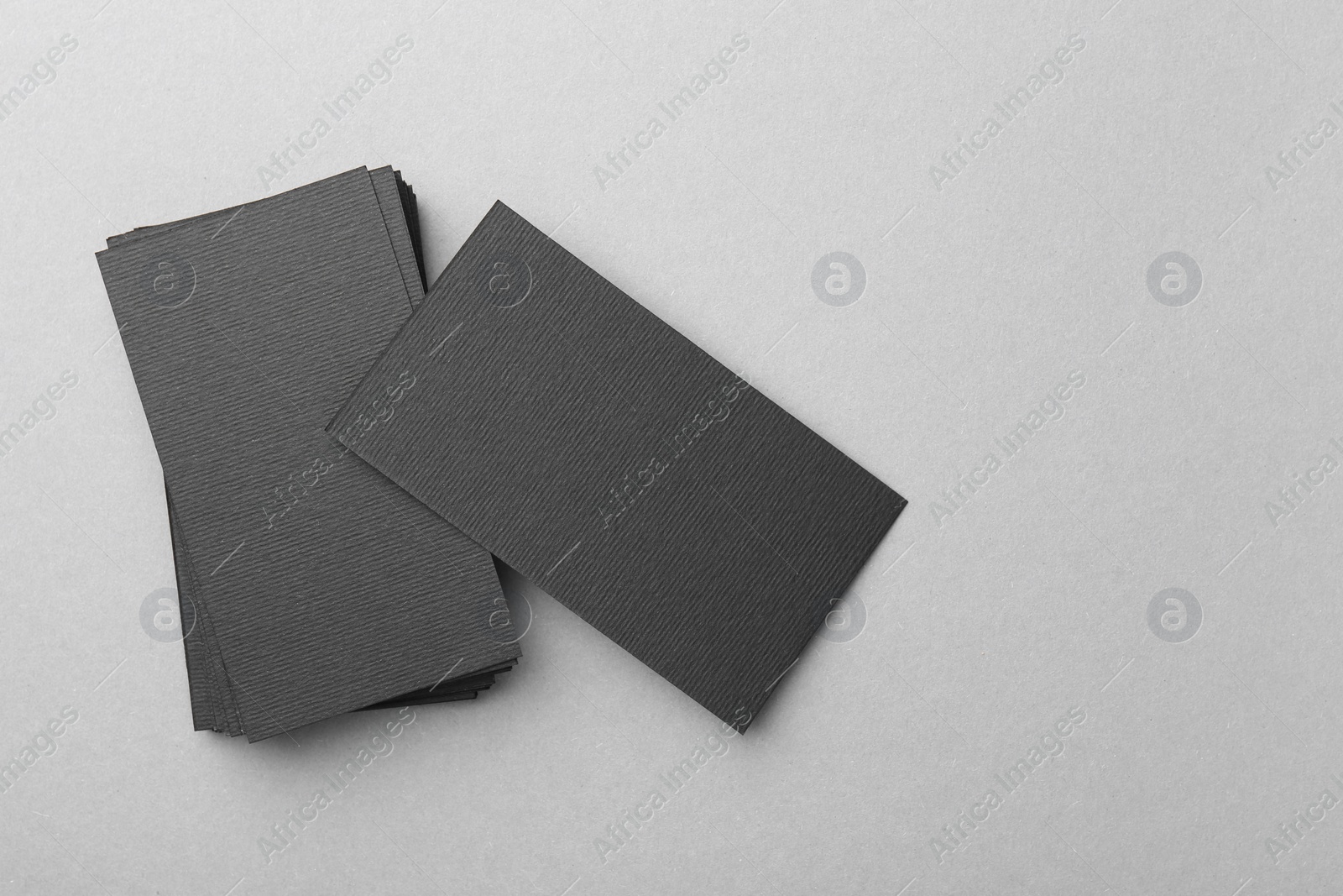 Photo of Blank black business cards on light background, top view. Mockup for design