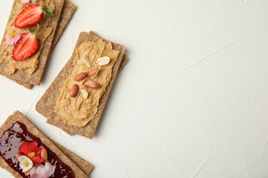 Photo of Fresh rye crispbreads with different toppings on white table, flat lay. Space for text