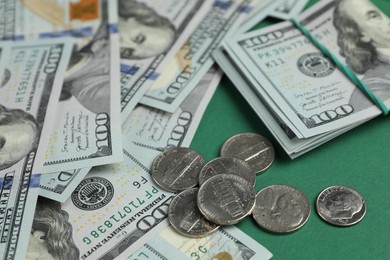 Photo of Money exchange. Dollar banknotes and coins on green background, closeup