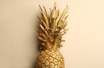 Photo of Golden pineapple on beige background, top view. Creative concept