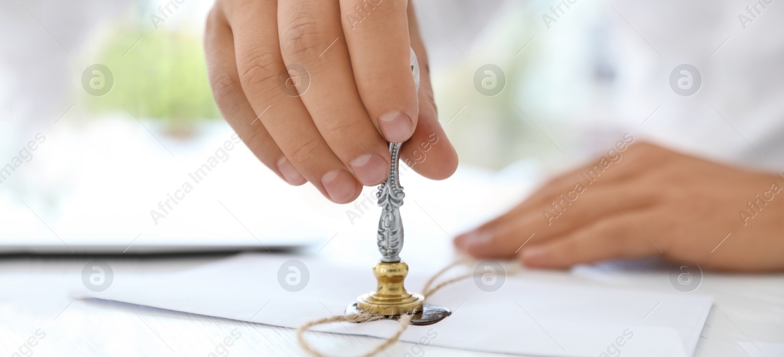 Image of Male notary stamping document at table, closeup. Banner design