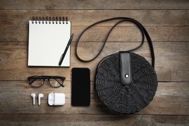 Flat lay composition with stylish woman's bag, smartphone and accessories on wooden background