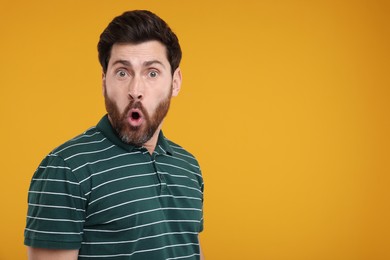 Portrait of surprised man on yellow background, space for text