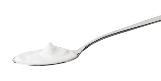 Photo of One silver spoon with sour cream isolated on white