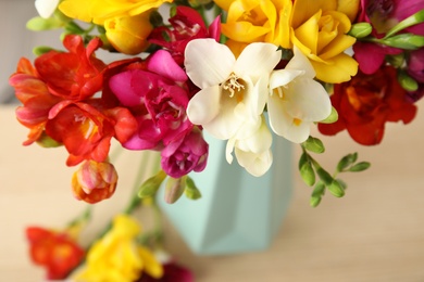 Photo of Beautiful spring freesia flowers on table, closeup