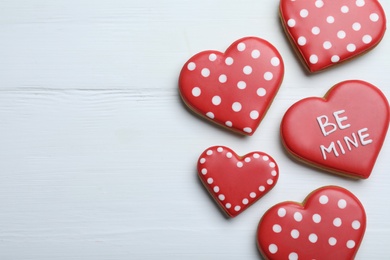 Photo of Delicious heart shaped cookies on white wooden table, flat lay with space for text. Valentine's Day