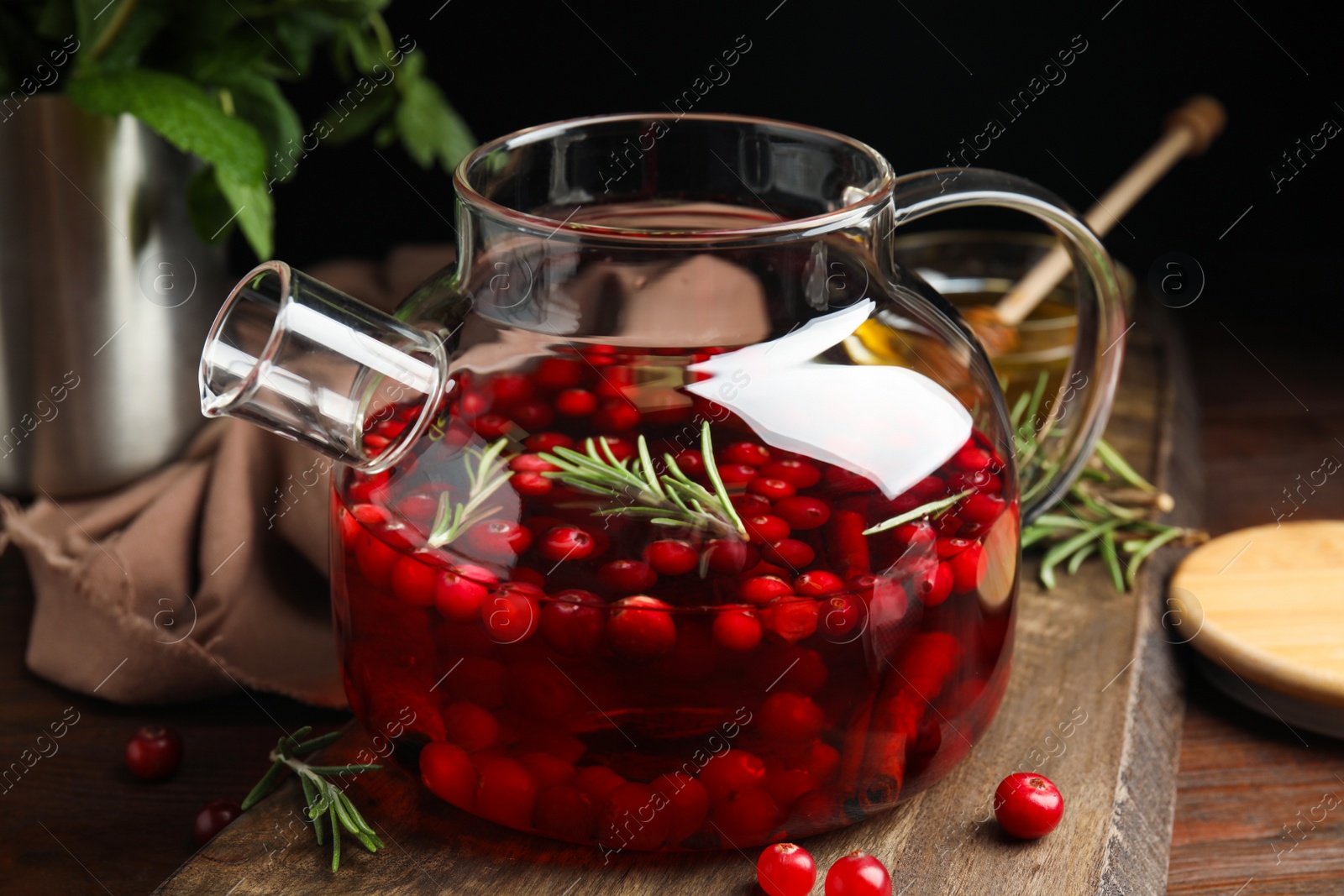 Photo of Tasty hot cranberry tea and fresh ingredients on wooden table