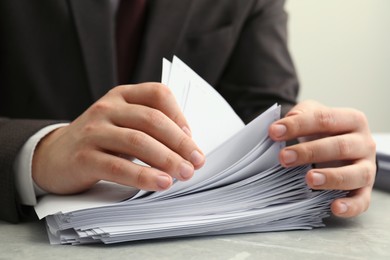 Photo of Man stacking documents at table in office, closeup