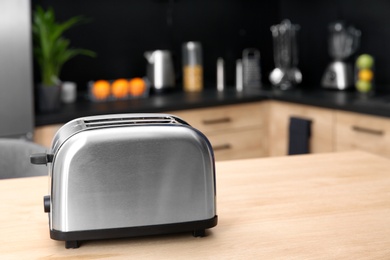 Photo of Modern toaster on table in kitchen, selective focus