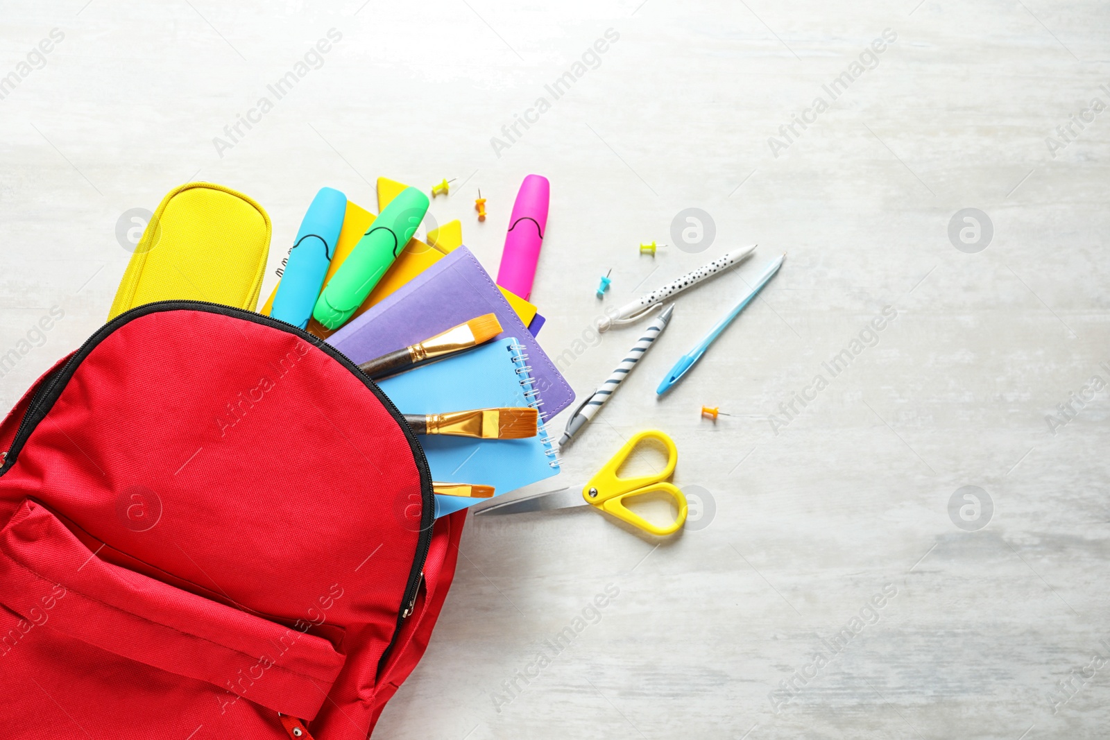 Photo of Flat lay composition with backpack, school stationery and space for text on light background