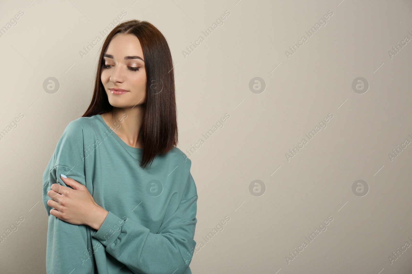 Photo of Portrait of pretty young woman with gorgeous chestnut hair on light background, space for text