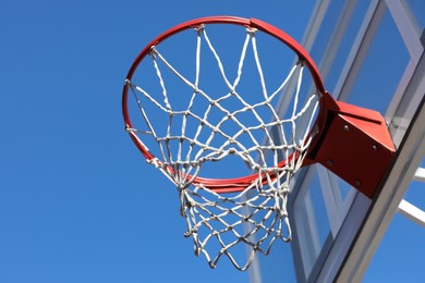 Basketball hoop with net outdoors on sunny day, low angle view