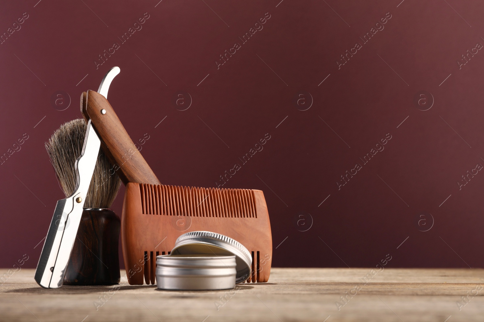 Photo of Moustache and beard styling tools on wooden table. Space for text