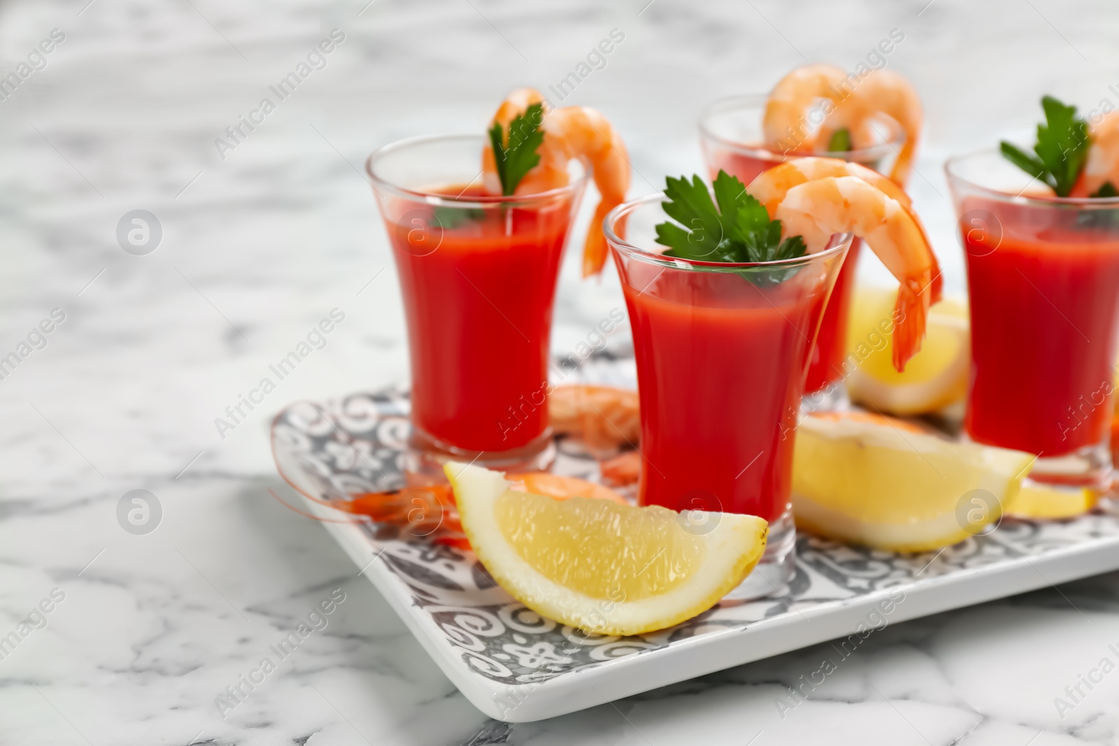 Photo of Shrimp cocktail with tomato sauce served on marble table