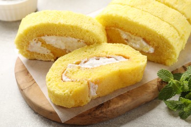 Photo of Delicious cake roll with cream filling on table, closeup