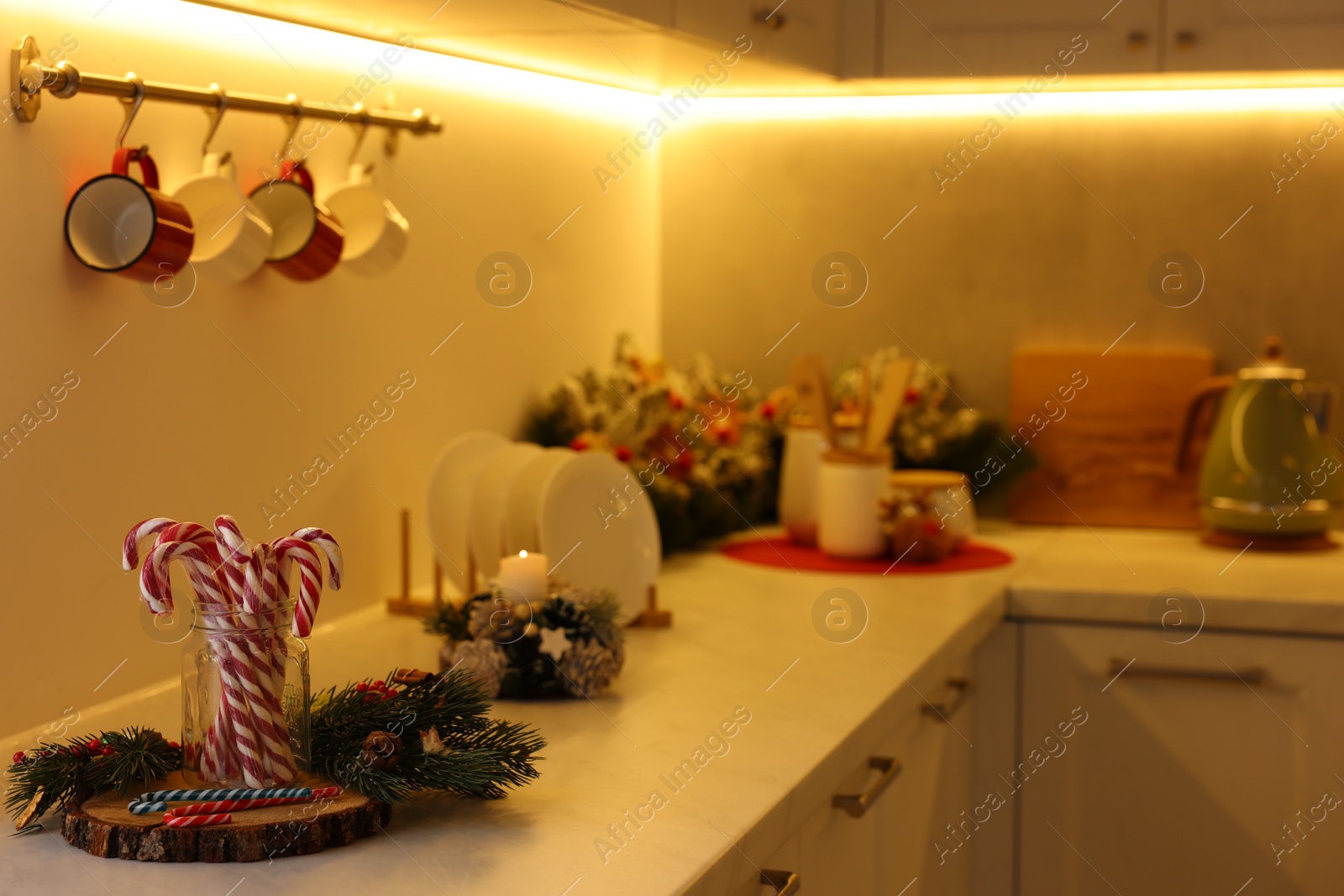 Photo of Christmas decor and candy canes on countertop in kitchen, space for text