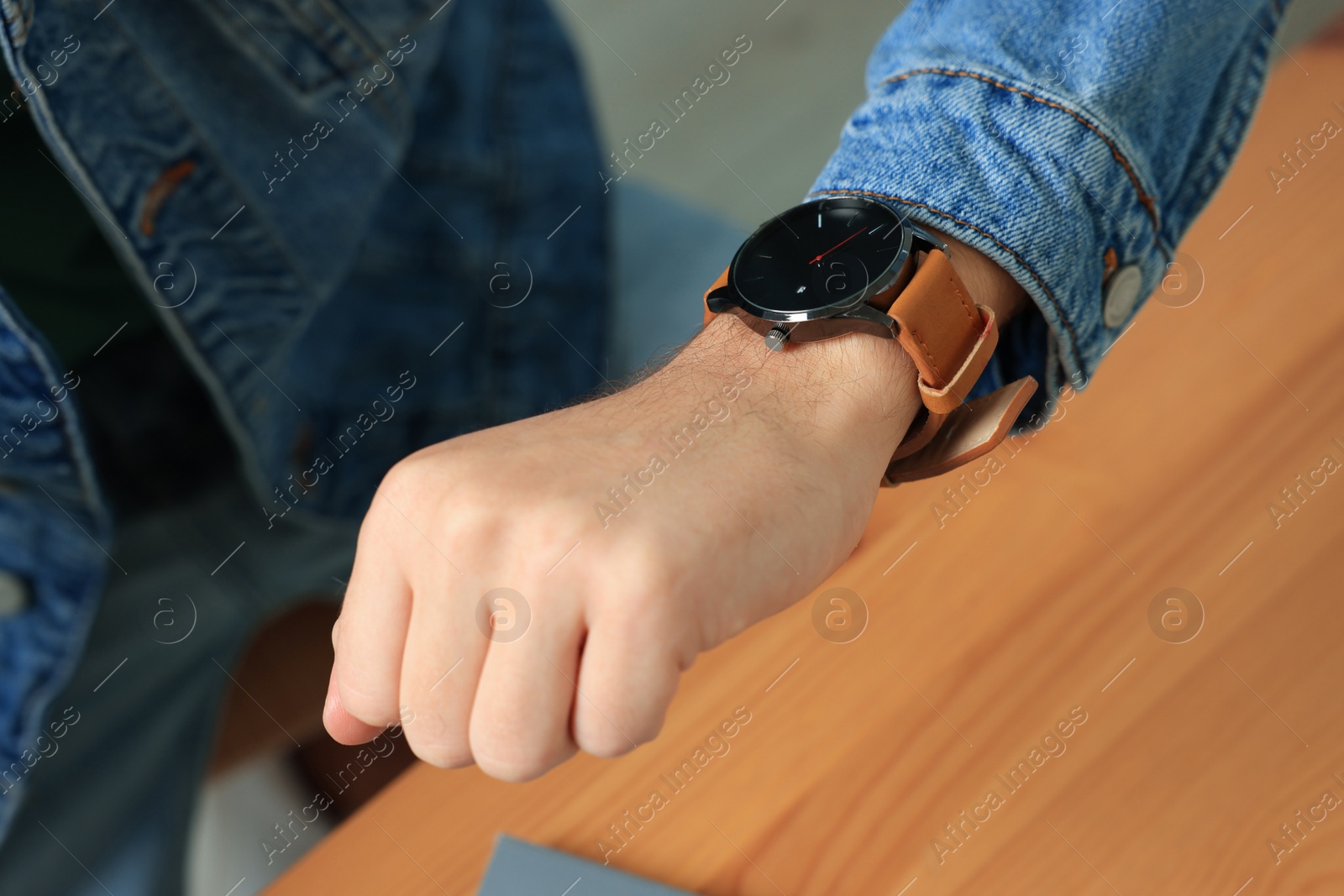 Photo of Man checking time in room, closeup. Being late