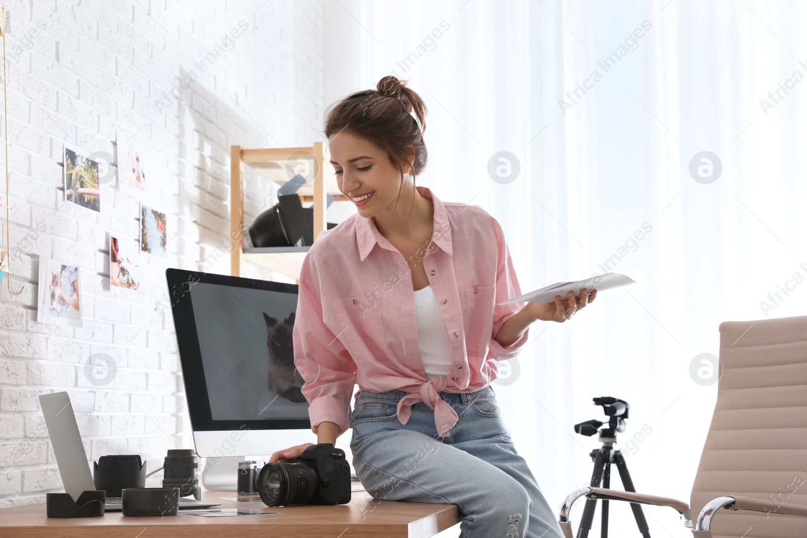 Photo of Professional photographer with camera working in light modern office