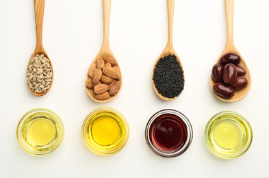 Photo of Vegetable fats. Different cooking oils in bowls and spoons with ingredients on white background, flat lay