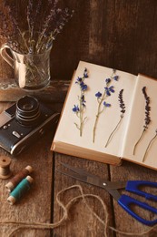 Composition with beautiful dried flowers and vintage camera on wooden table
