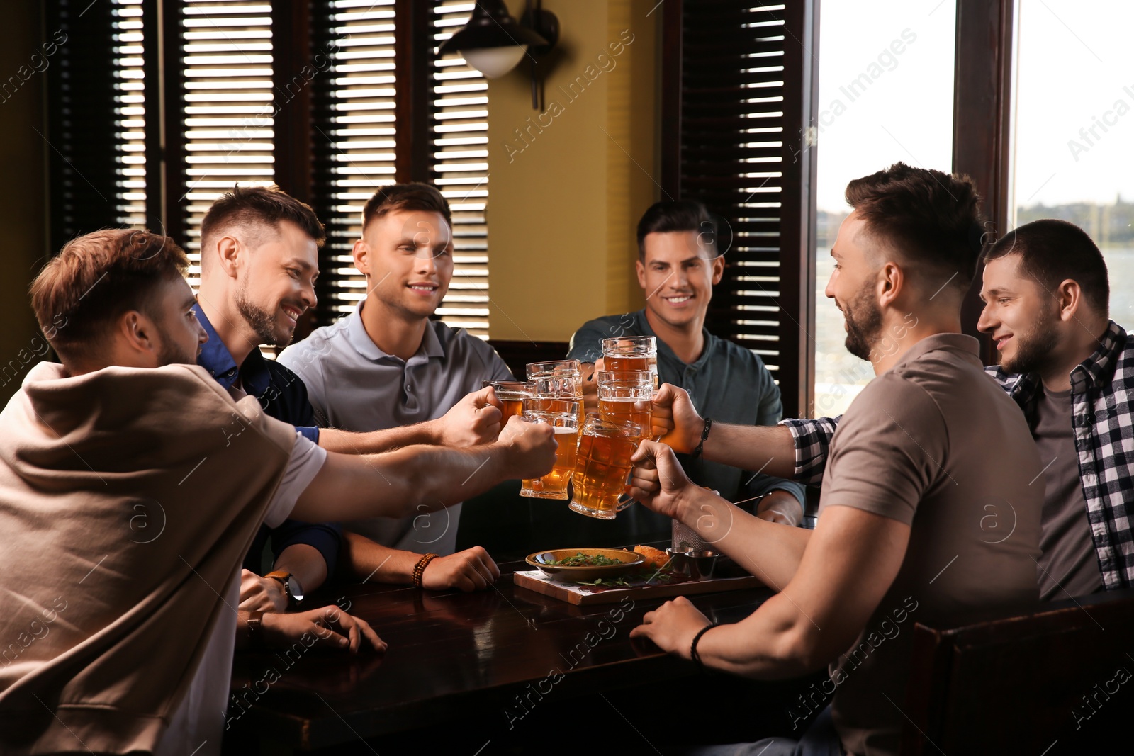 Photo of Friends clinking glasses with beer in pub