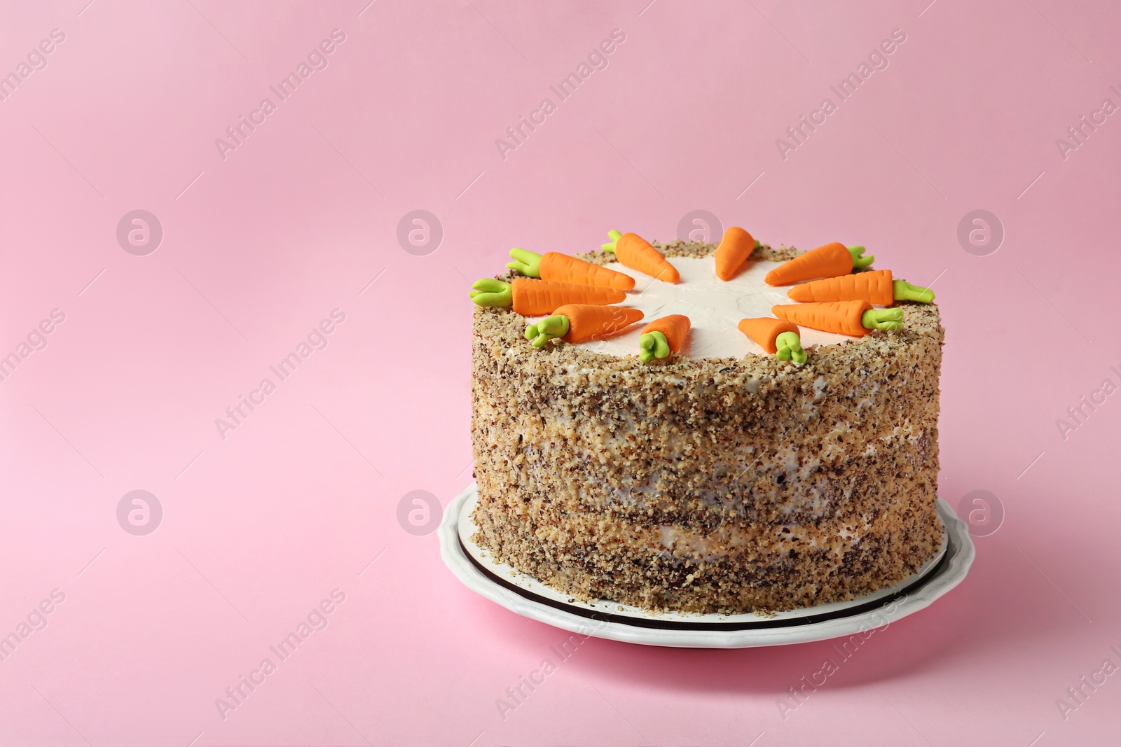 Photo of Dish with tasty carrot cake on pink background, space for text