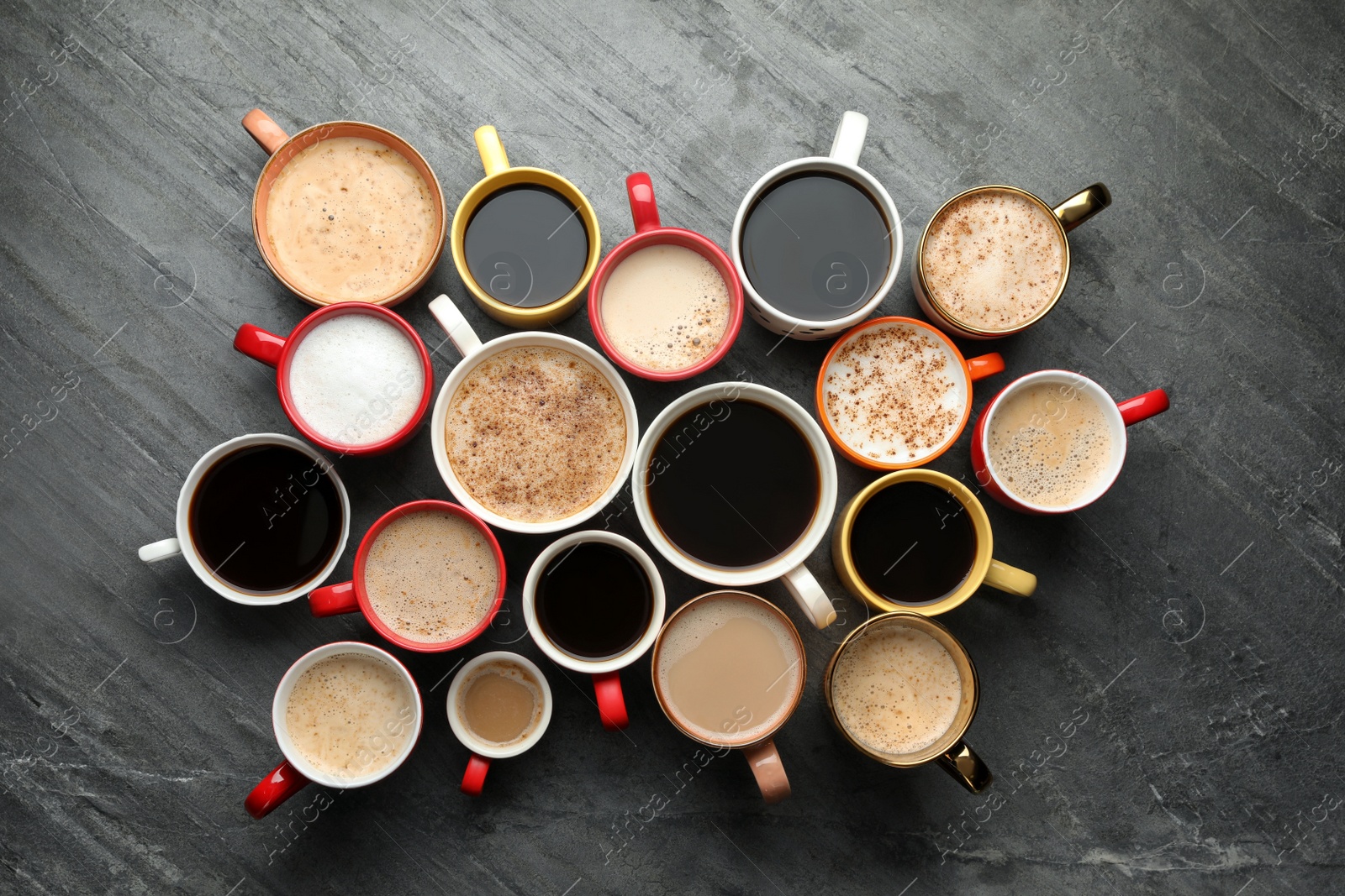 Photo of Many cups of different coffees on slate table, flat lay