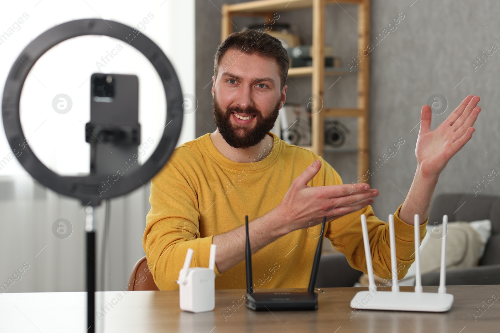 Photo of Smiling technology blogger recording video review about WI-FI devices at home