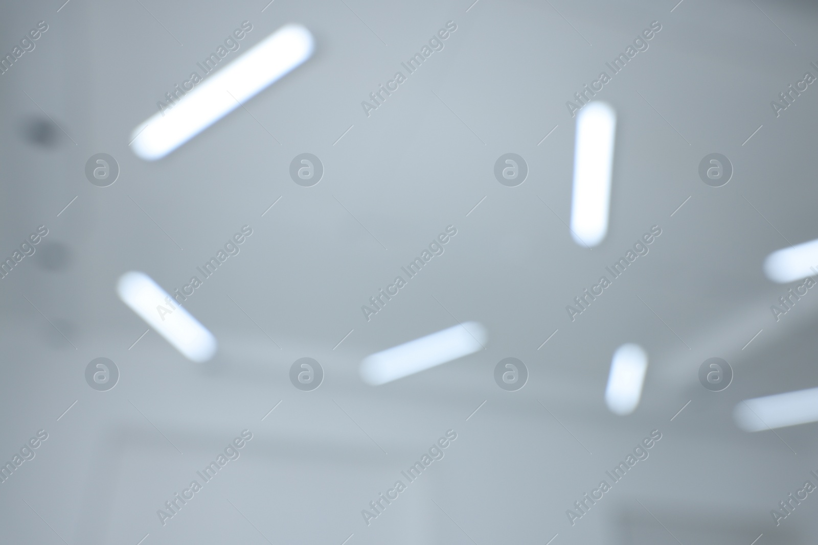 Photo of Blurred view of white ceiling with modern lights