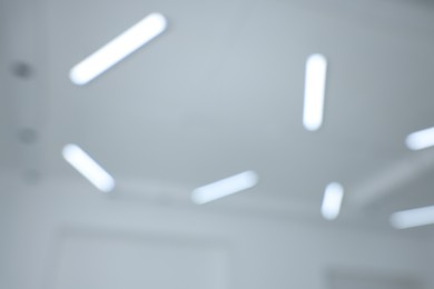 Photo of Blurred view of white ceiling with modern lights