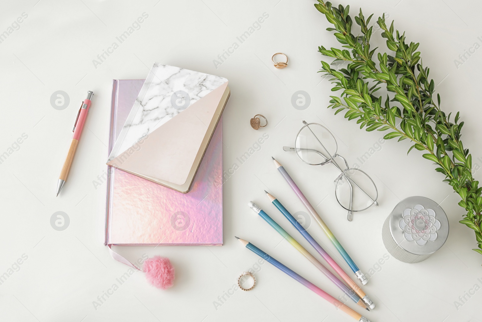 Photo of Flat lay composition with notebooks and green branch on light background. Blogger's workplace