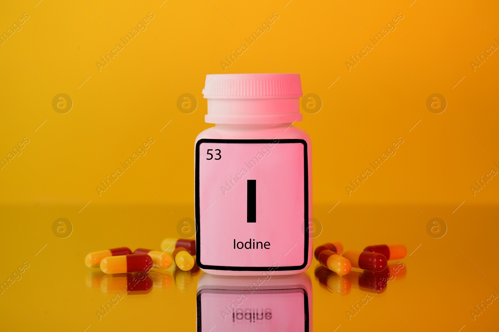 Photo of Bottle of medical iodine and pills on yellow background, color tone effect